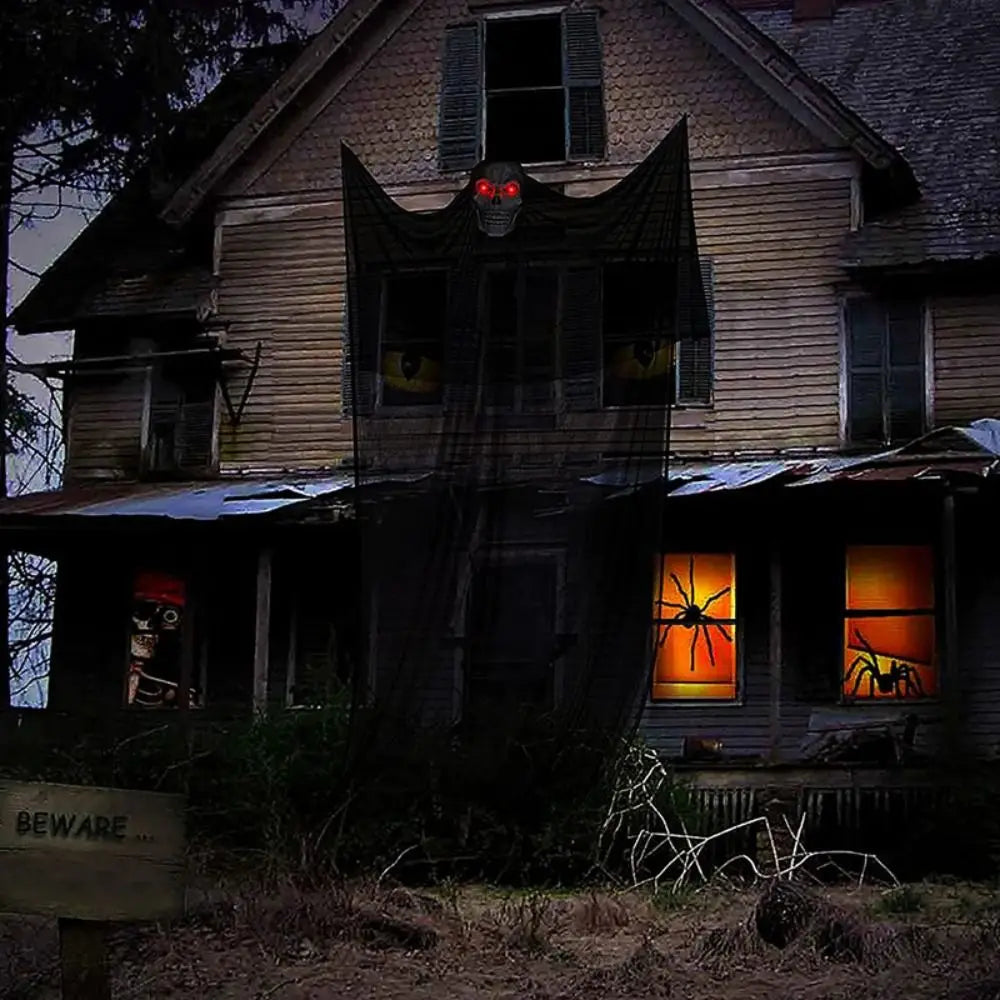 Halloween ghost decoration with glowing eyes hung from a balcony