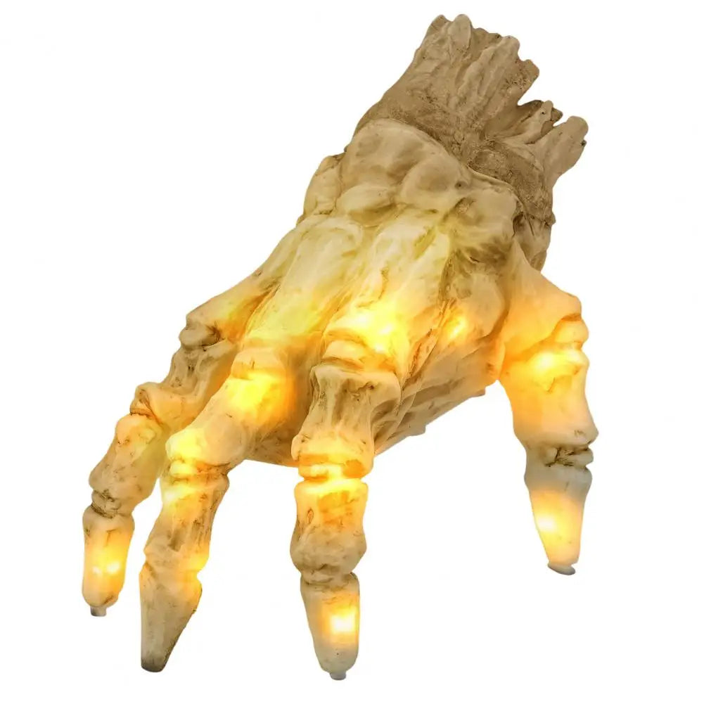 Halloween skeleton hand prop lit up in a dark haunted house scene