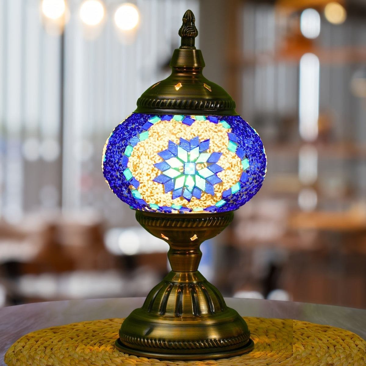 Blue mosaic stained glass pumpkin lamp lit on a table