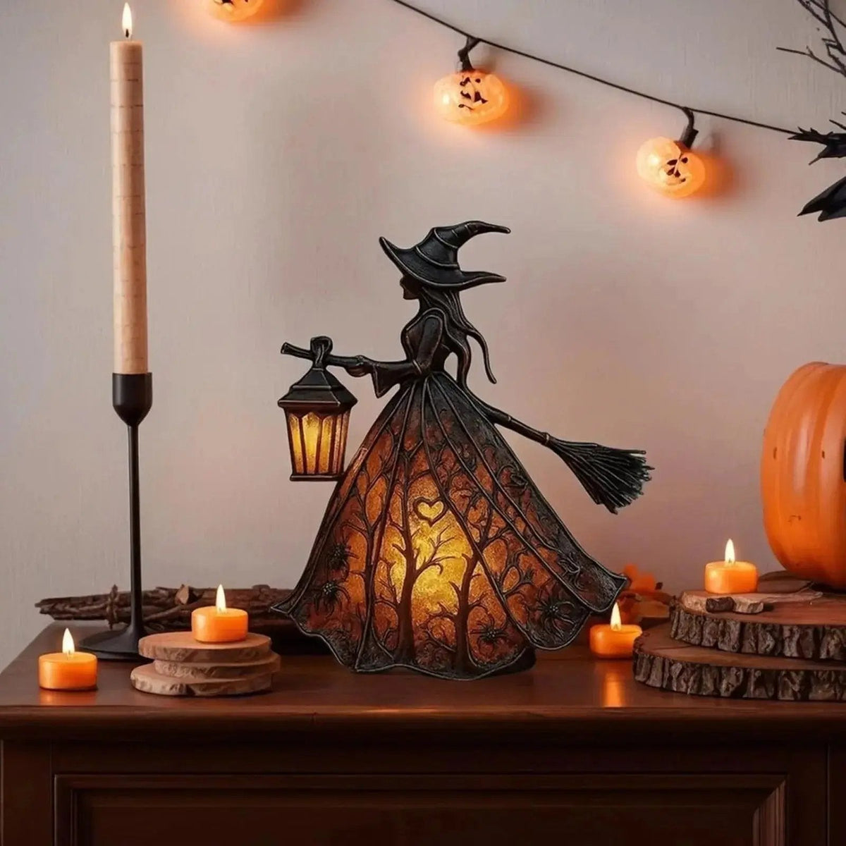 Resin witch figurine holding a glowing lantern