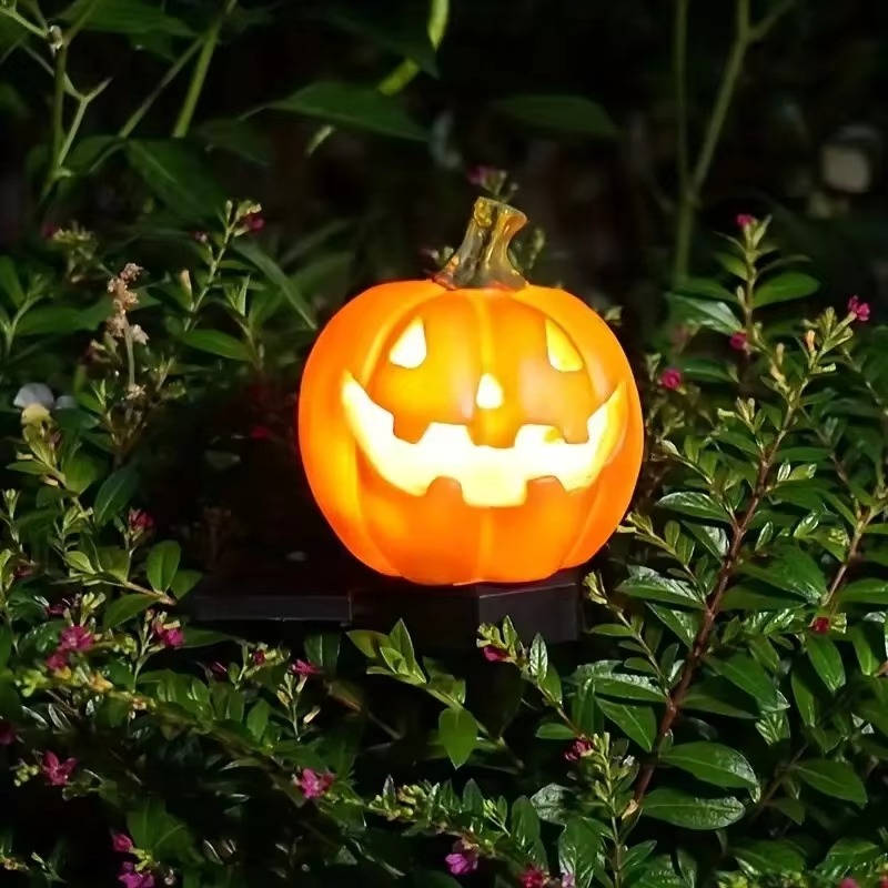 Halloween solar pumpkin light staked into a lawn