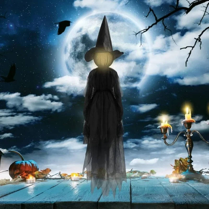 Witch figures with glowing heads displayed in a yard at night