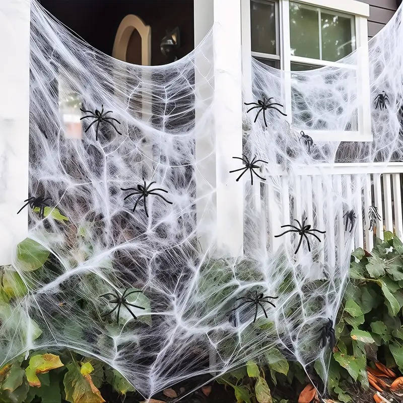 Halloween spider webbing stretched outdoors across a porch