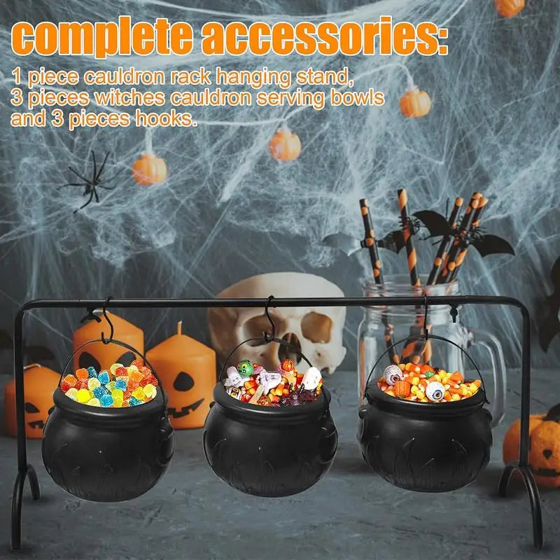 Witch cauldron candy bowls filled with Halloween treats on a party table