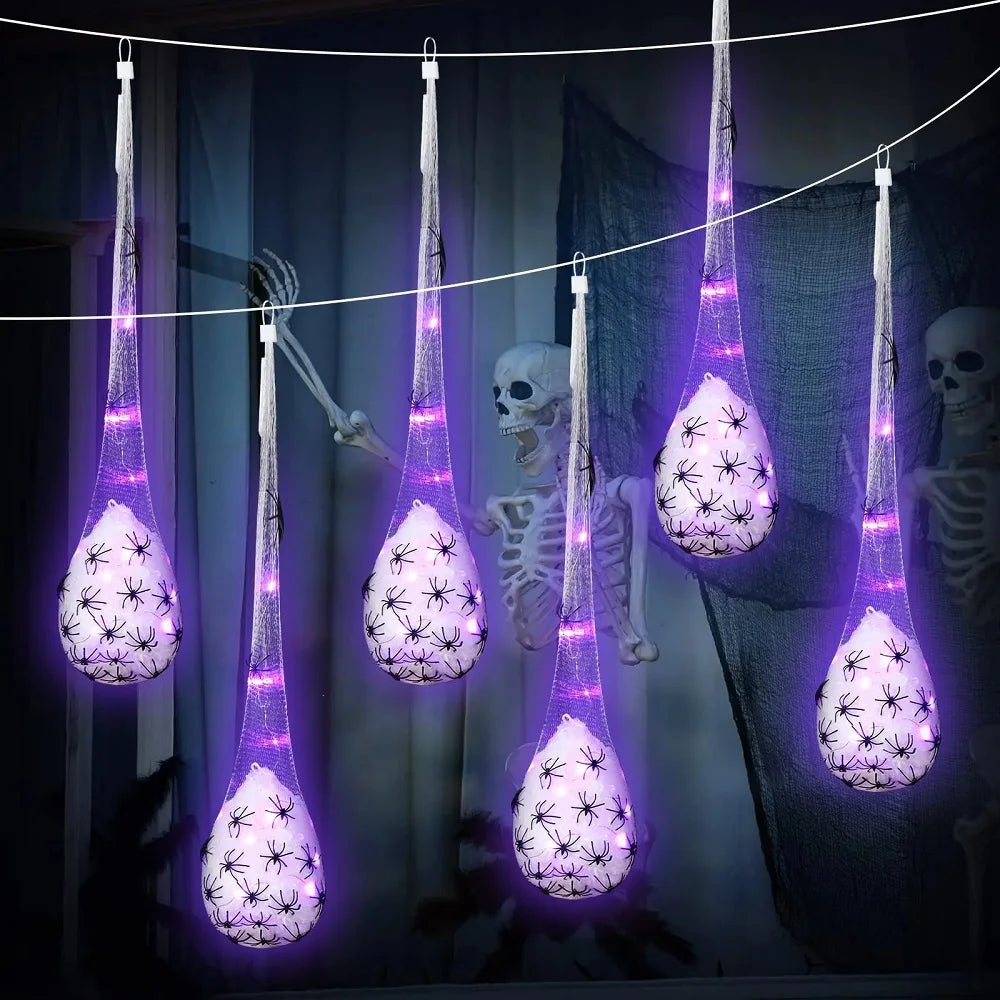 Light-up spider egg sac hung from a tree branch outdoors