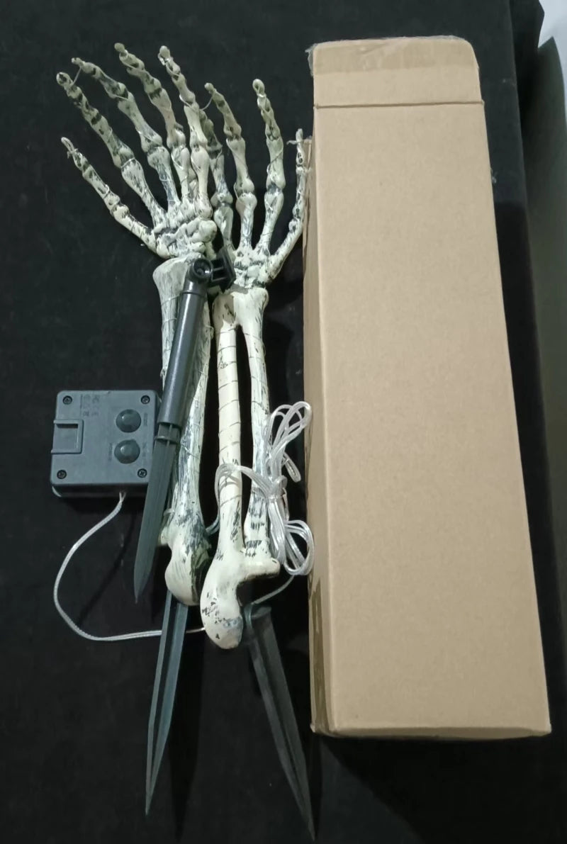 Pair of skeleton hand solar lights in a Halloween graveyard scene