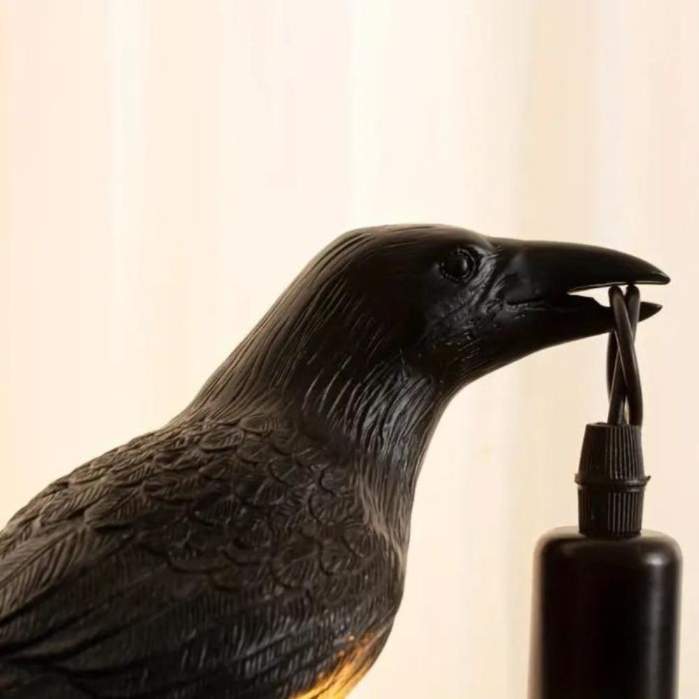 Raven accent lamp lit on a dark shelf