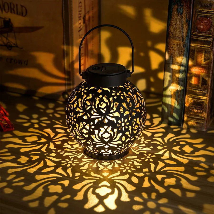 Solar powered hanging iron lantern glowing in a garden
