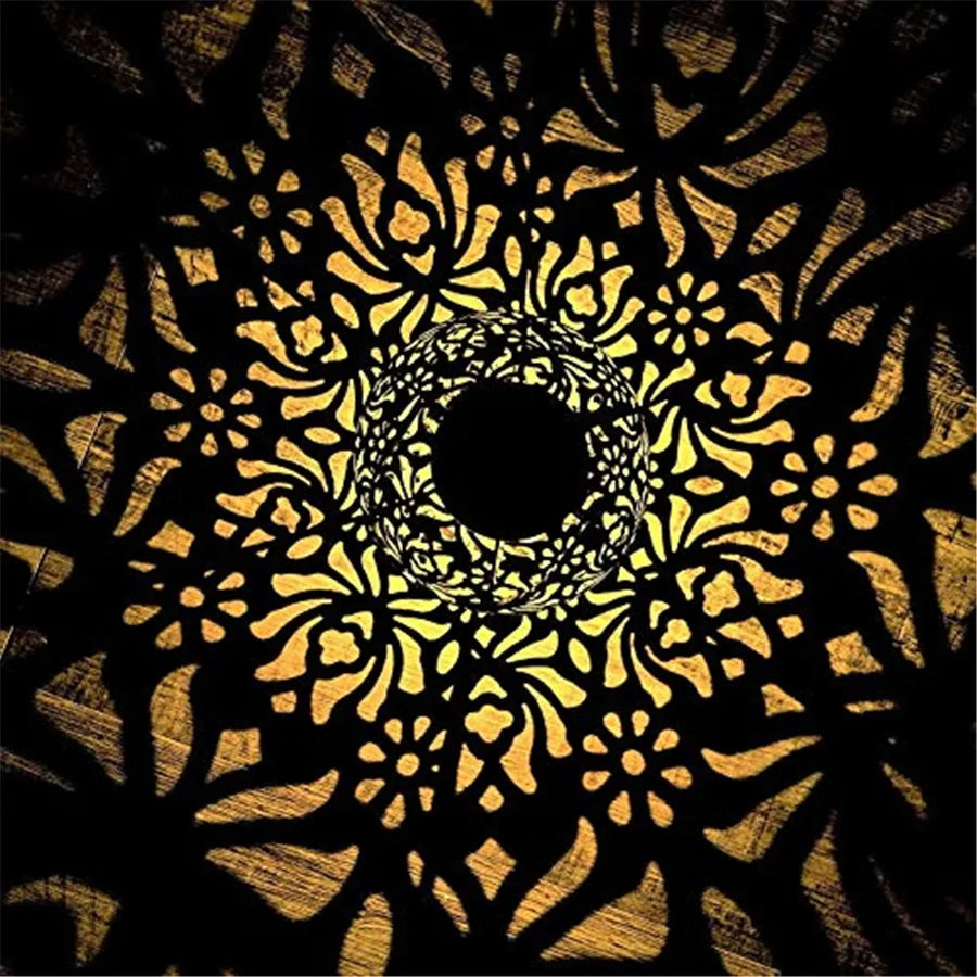 Hollow iron cutwork lantern projecting patterns onto a wall