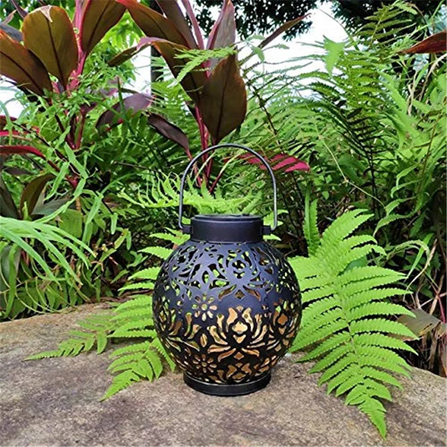 Decorative solar garden light hung from a tree branch