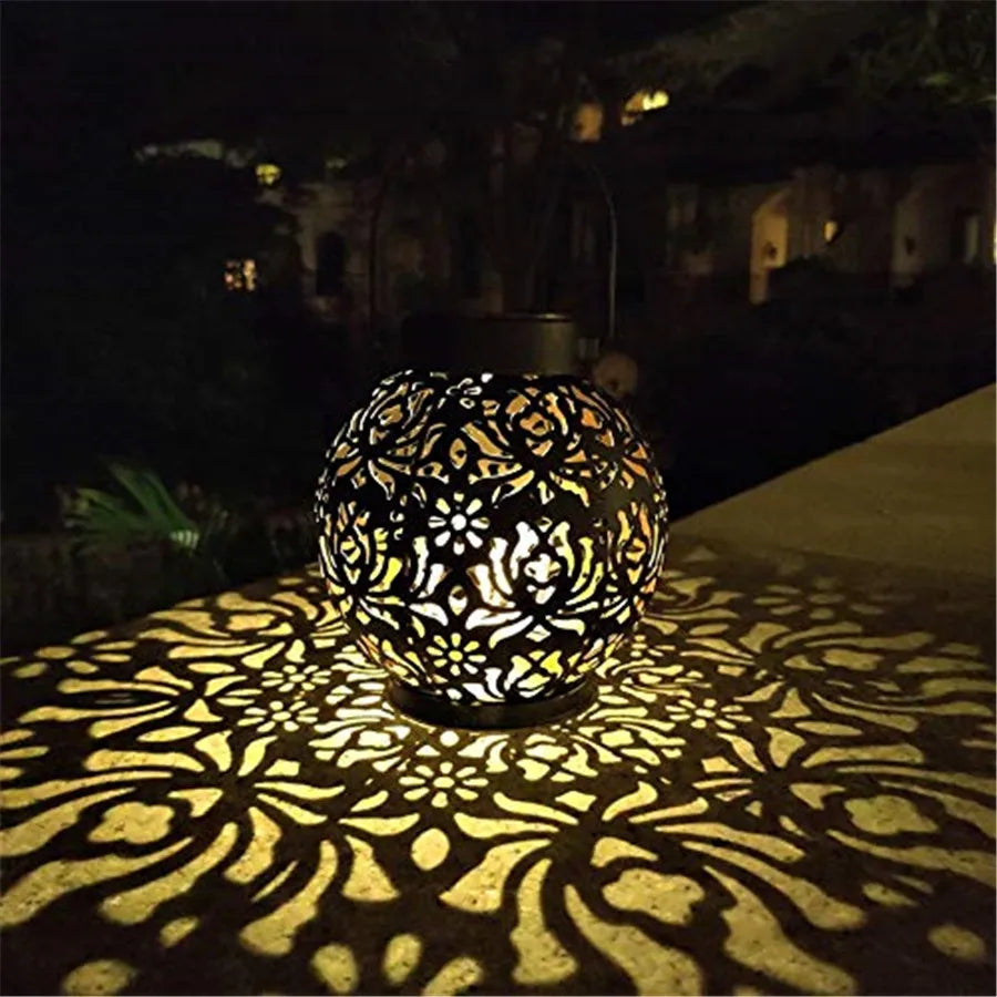 Solar hanging light with integrated hook on a garden fence