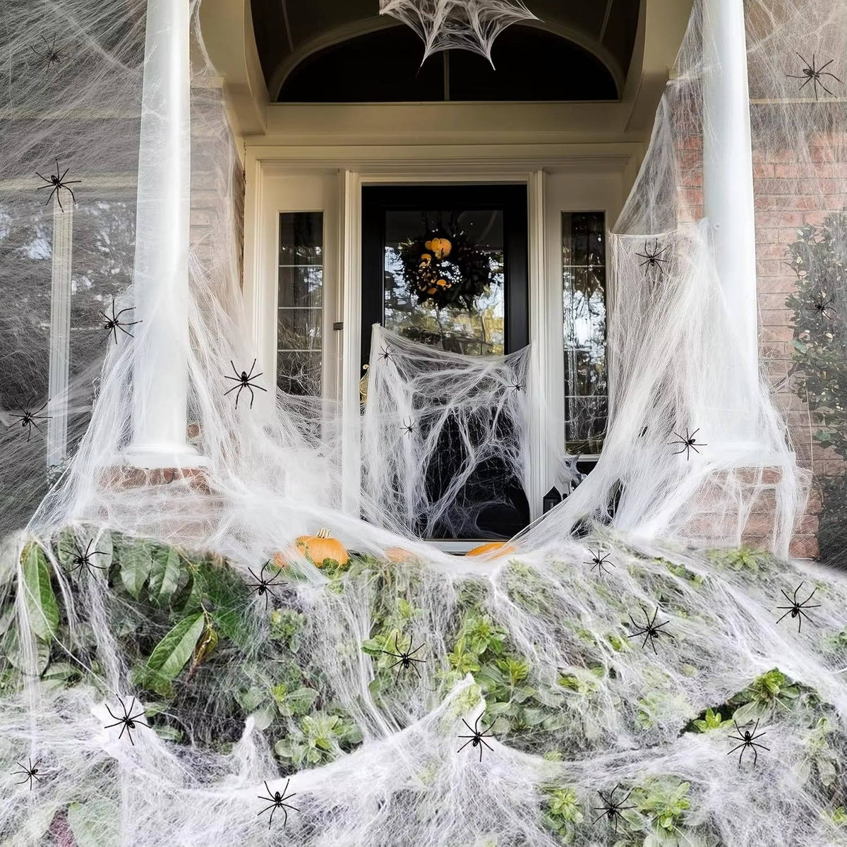 Halloween cobweb decoration stretched over a doorway with plastic spiders